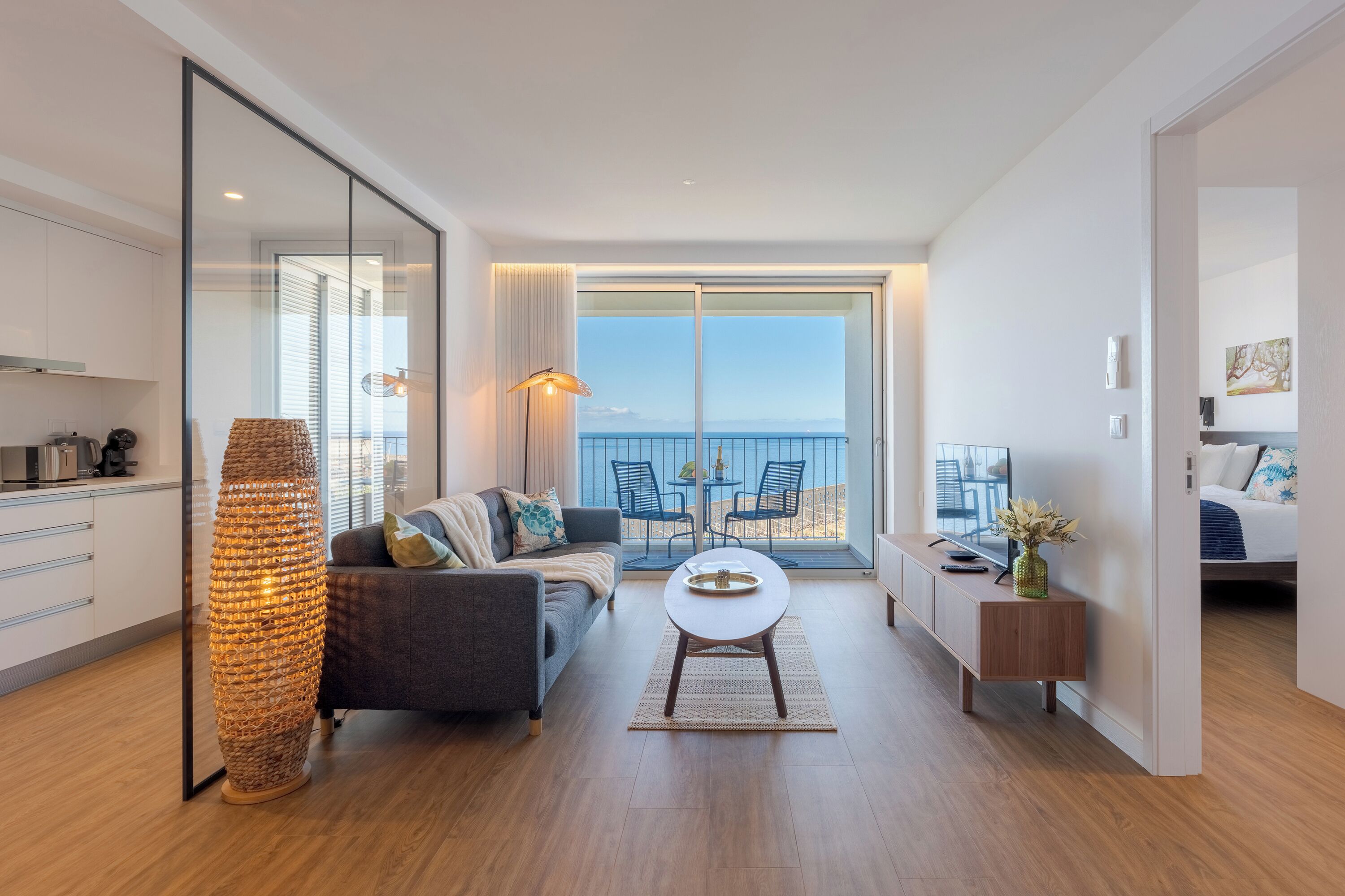 A modern living room with a sofa, coffee table, and a tall floor lamp.