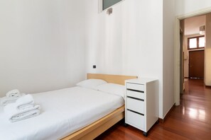 2 dormitorios y tabla de planchar con plancha