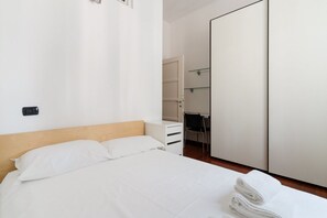 Une chambre à coucher avec un lit, un bureau et une armoire.