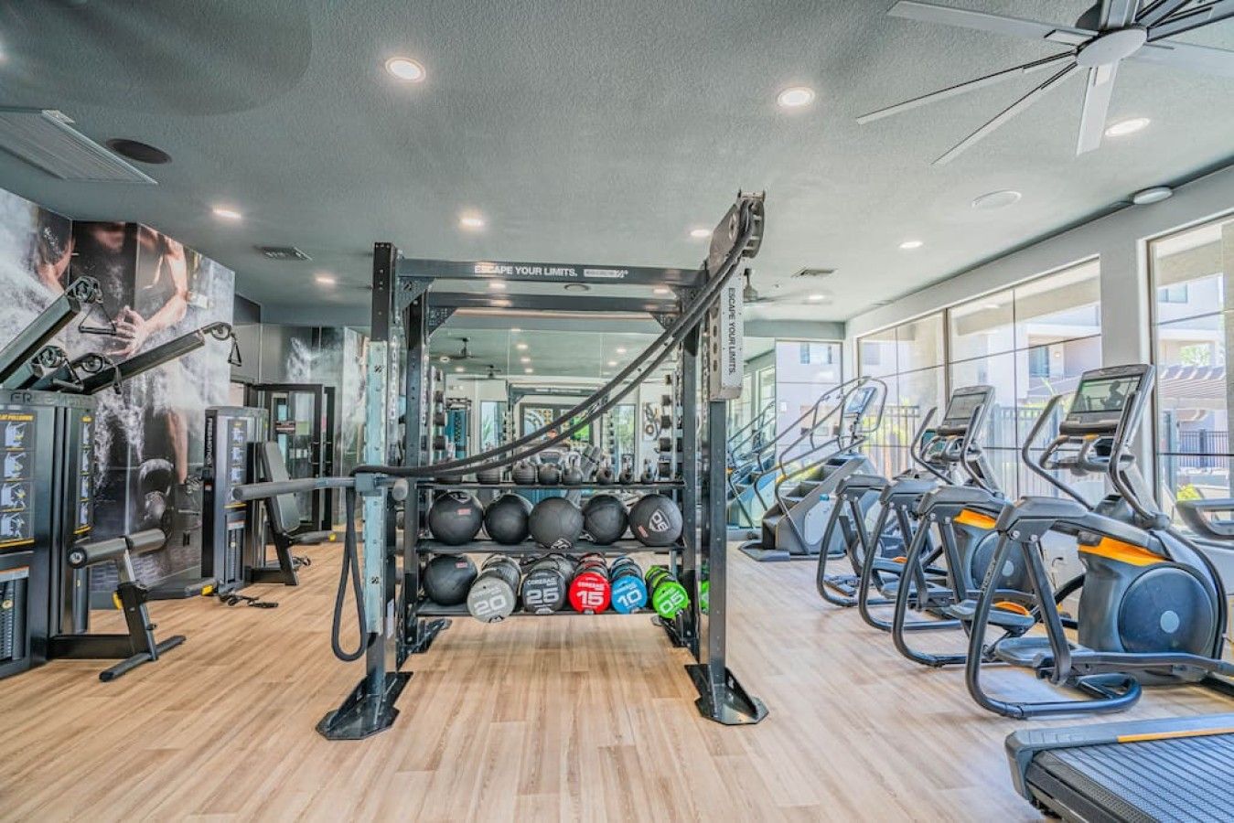 Ett gym med träningsutrustning, löpband och en vägg med motiverande affischer.