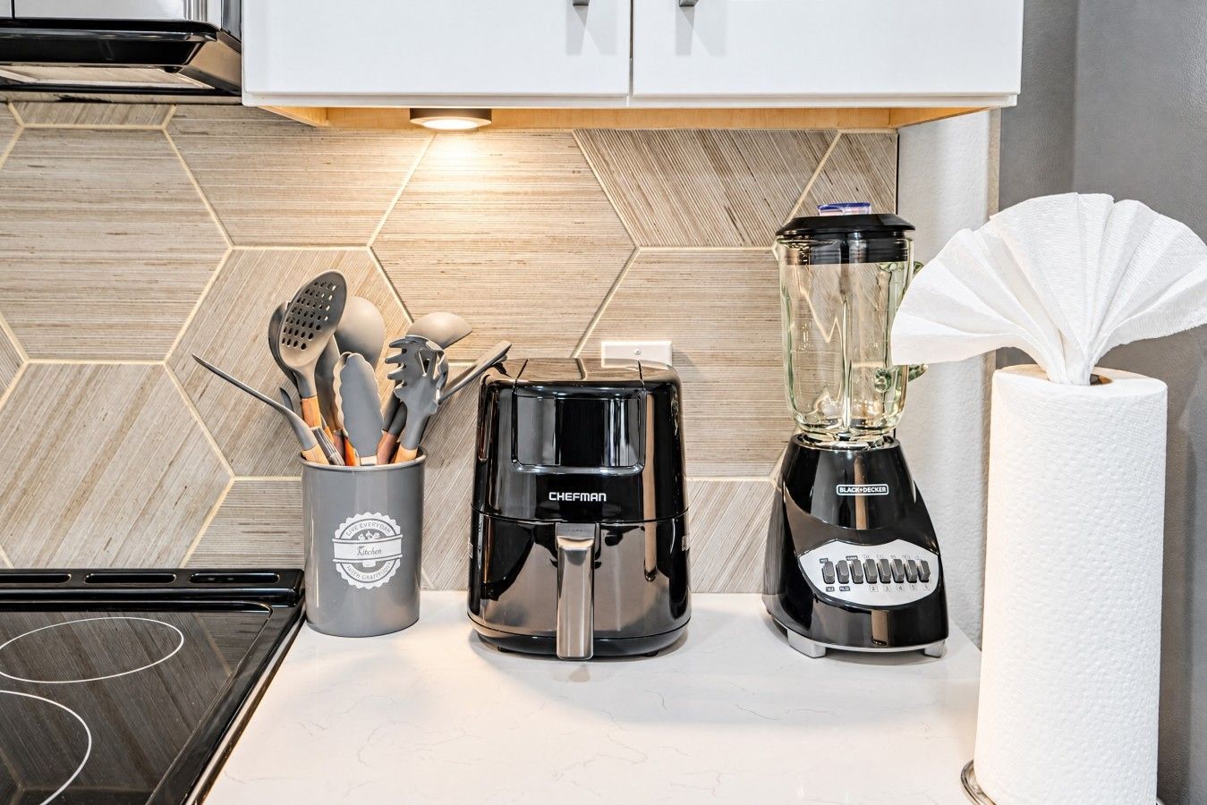 Eine Küche mit Kaffeemaschine, Mixer und Besteckhalter.
