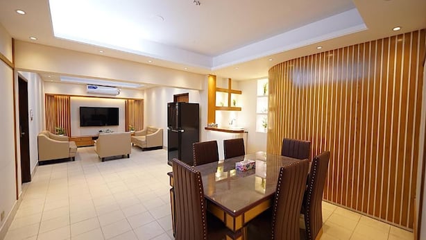 A modern living room with a dining area, a flat-screen TV, and a refrigerator. - Tourister Bd Ltd (Dhaka)