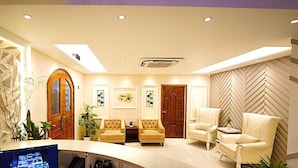 A modern reception area with a curved reception desk, two sofas, and a large wooden door. - Tourister Bd Ltd (Dhaka)