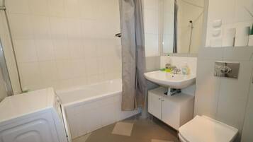 Un baño con bañera, inodoro, lavabo y ducha.