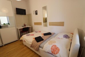 A bedroom with a bed, a desk, a chair, a TV, and a mirror. - Fantastic Inn Warsaw - NS54 (Warsaw)