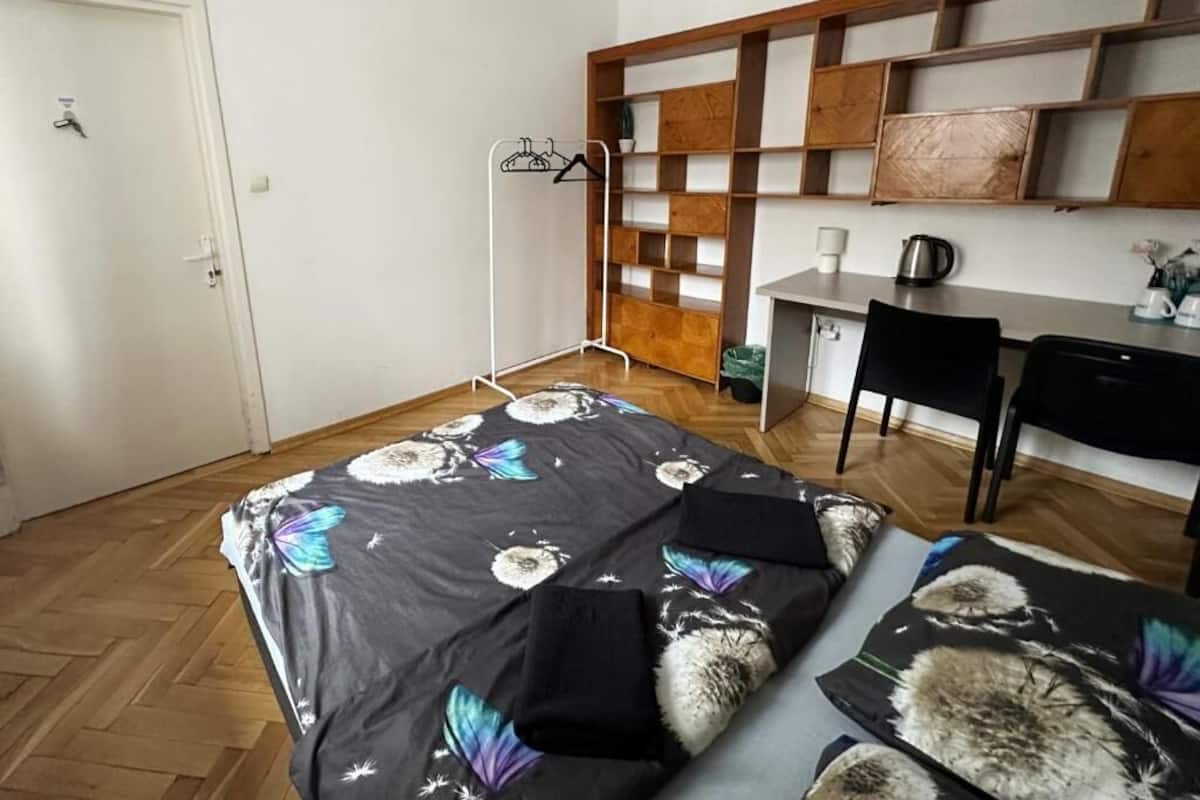 A bedroom with a bed, a desk, a chair, and a wardrobe.