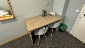 A small room with a wooden desk, two white chairs, a kettle, cups, and a trash bin. - Fantastic Inn Warsaw - NS54 (Warsaw)