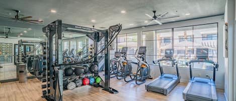 A gym with exercise equipment, treadmills, and weightlifting stations.