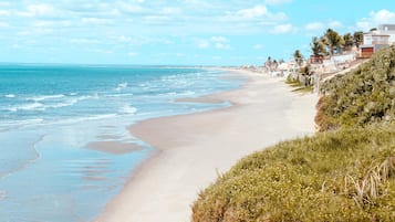 Na praia, espreguiçadeiras, guarda-sóis