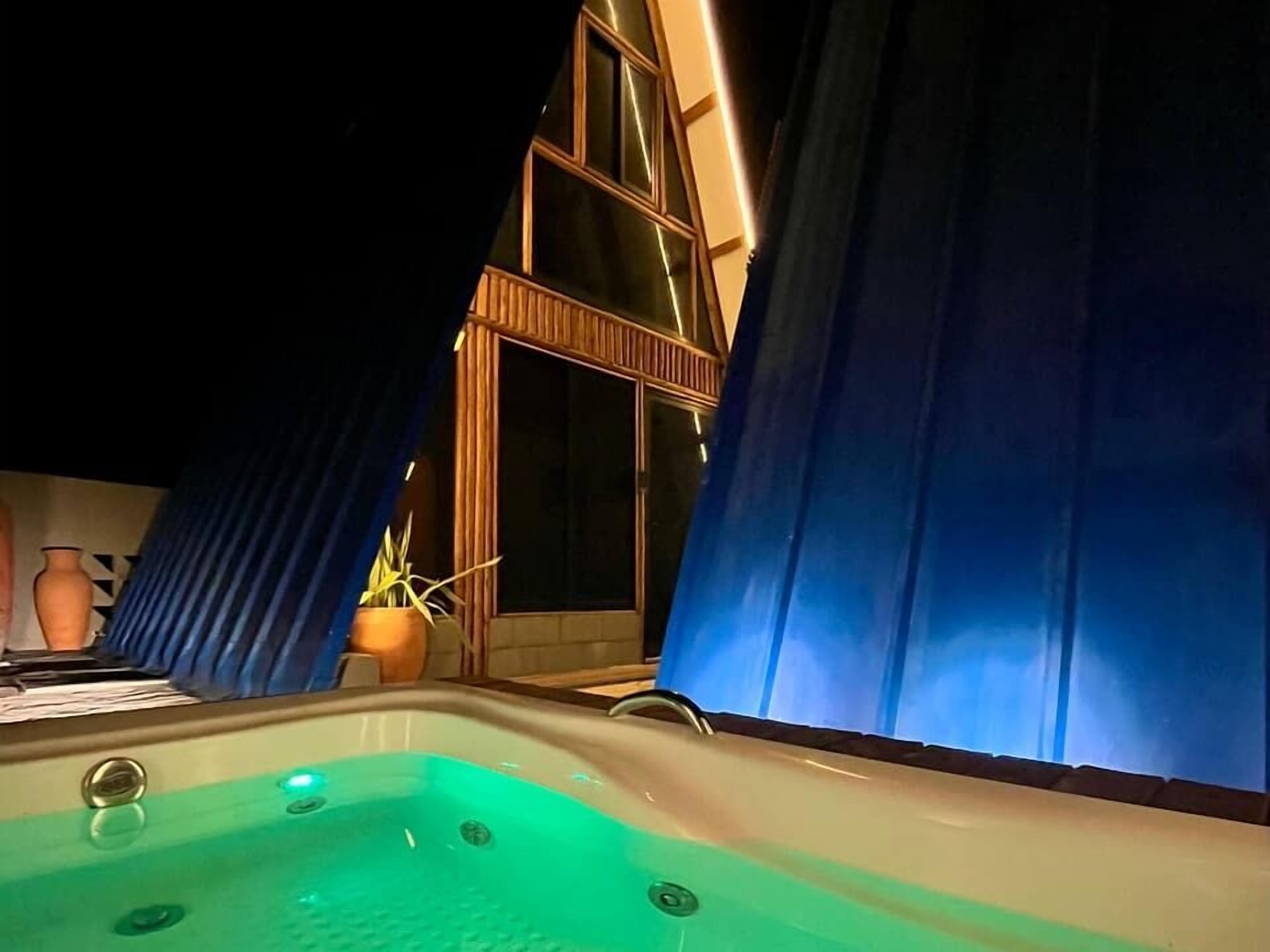 Un bain à remous avec vue sur un immeuble et des rideaux.