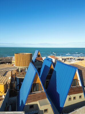 A coastal building with multiple blue roofs and a wooden structure. - Pousada Quilombo do Tibau (Tibau)