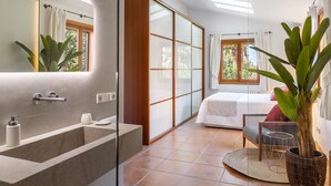 Une salle de bain moderne avec un grand miroir, une baignoire et un espace douche.