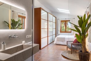 Une salle de bain moderne avec un grand miroir, une baignoire et un espace douche.