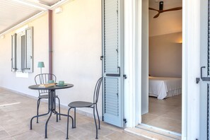 Una habitación con una cama, una mesa con sillas y una puerta que da a otra habitación.