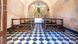 A church interior with pews, a checkered floor, and an altar with a religious icon.