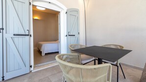 A room with a bed, a table, and two wicker chairs. - Room 'Linda' with shared pool, Wi-Fi and air conditioning (Alghero)
