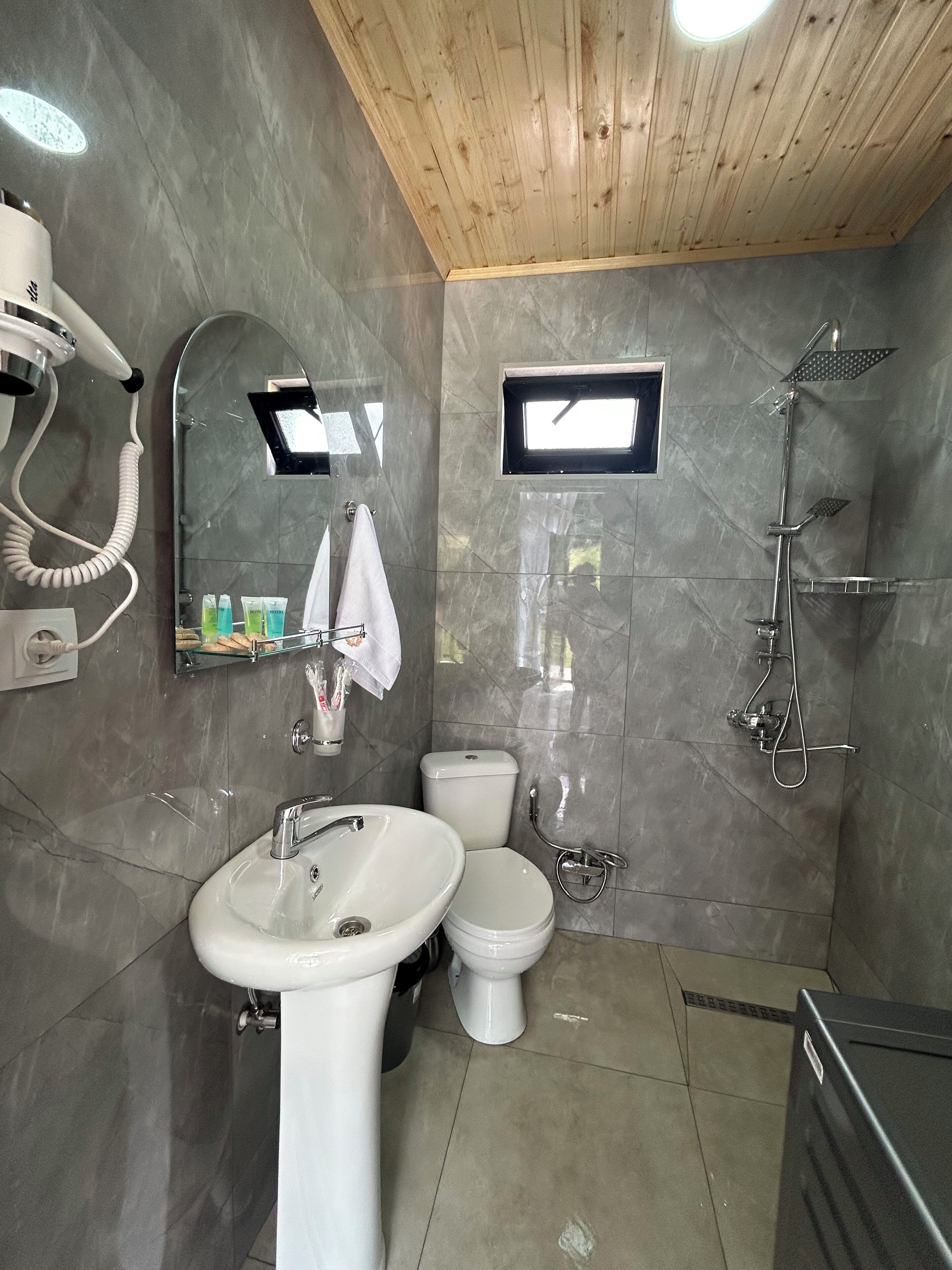 Uma casa de banho moderna com lavatório, sanita e chuveiro.