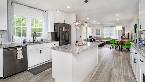 A modern kitchen with white cabinetry, granite countertops, and stainless steel appliances. - Cozy Corner: Spacious Area & Outdoor Lounges! (Knoxville)