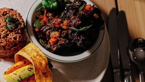 A plate with rice, a bowl of meat dish, and a wrap. - Negril Footeprints Hotel (Negril)