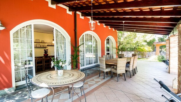 A covered patio with a round table and chairs, a potted plant, and a view of the garden. - VILLA LISA - COUNTRY HOUSE LISA. HOUSE WITH GARDEN 7 MINUTES WALK FROM THE SEA (Diano Marina)