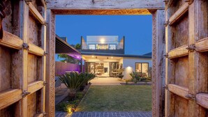 Une maison moderne avec une pelouse bien entretenue et une allée pavée menant à l’entrée.