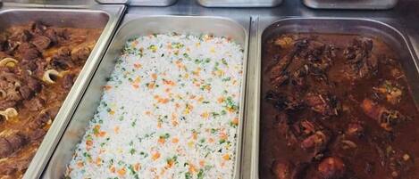 Un bufé con diversos platos, incluyendo arroz, carne y ensaladas.