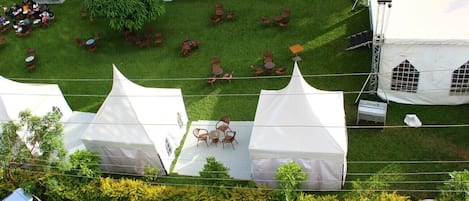 A campsite with tents and tables arranged on a grassy area.