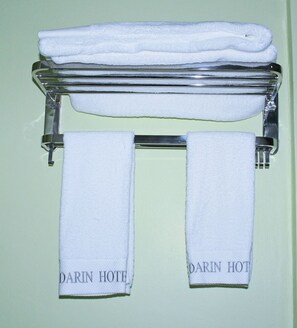 A towel rack with two folded white towels and two towels hanging below, each labeled "DARIN HOTEL". - Bedarin Hotel Ruiru (Ruiru)