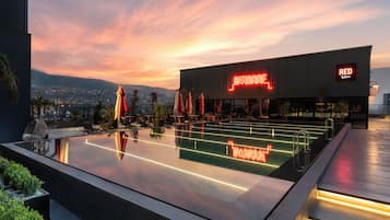 Una piscina al aire libre, sombrillas, sillones reclinables de piscina