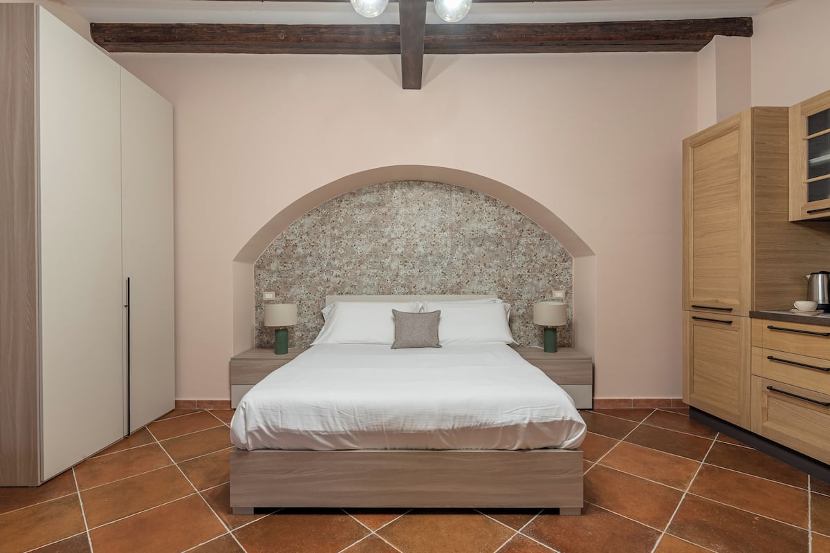 Ein Schlafzimmer mit einem großen Bett, einem Holzkopfbrett, Nachttischen und einem Schrank aus Holz.