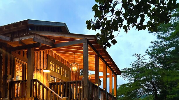 A wooden house with a covered porch and stone steps leading up to it. - Luxury Barn Retreat, Mountain Views and Creekside Calm (Ellijay)