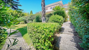 Un sendero en un jardín que lleva a un edificio con una escalera de piedra.