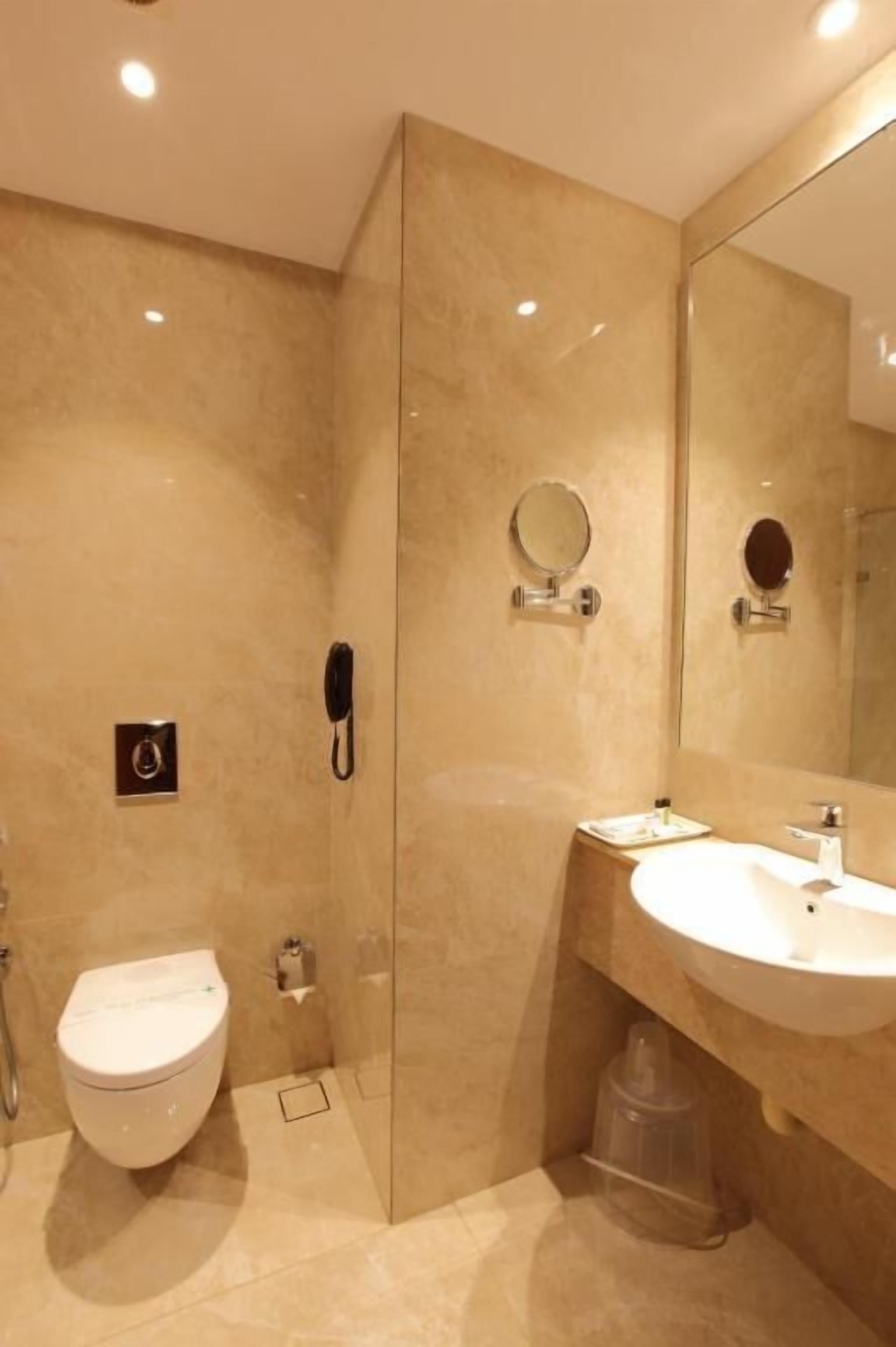 Et moderne badeværelse med toilet, vask og spejl.