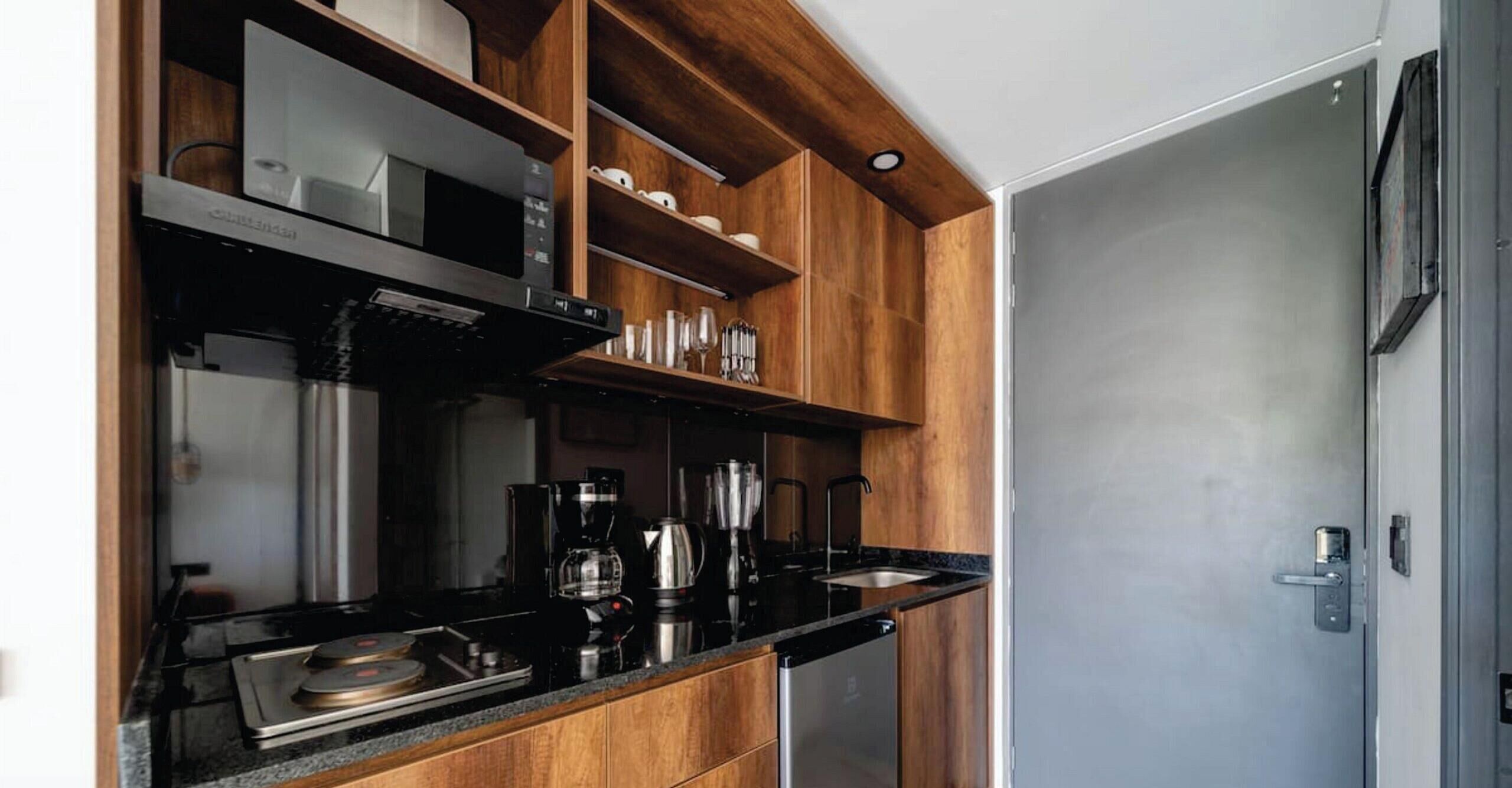 A modern kitchen with wooden cabinetry, a black countertop, and stainless steel appliances.