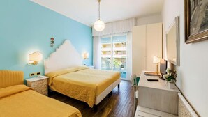 Ein Hotelzimmer mit zwei Betten, einem Schreibtisch und einem Balkon mit Blick.
