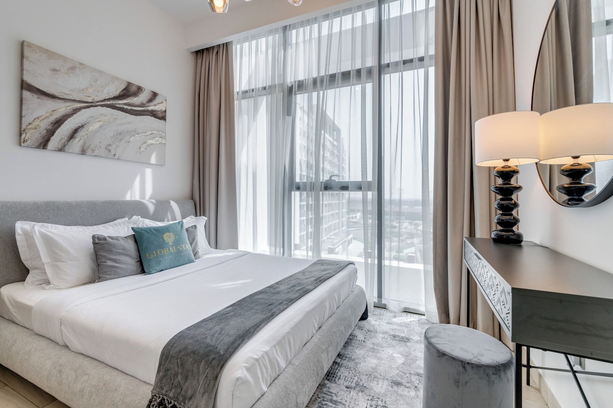 Una habitación de hotel moderna con una cama grande, un escritorio y vistas a la ciudad.