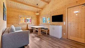 Ein Interieur einer Holzhütte mit Sofa, Tisch und Schränken.