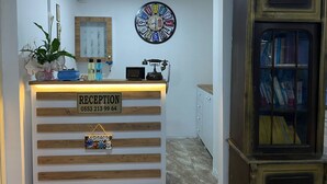 A reception desk with a sign reading "RECEPTION 0553 213 99 64". - Bonjourla Otel (Urla)