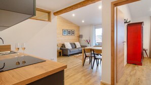 Una cocina moderna con encimera de madera y una zona de comedor con un armario rojo.