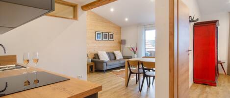 Una cocina moderna con encimera de madera y una zona de comedor con un armario rojo.