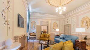 A spacious living room with a large blue sofa, a yellow armchair, and a marble coffee table. - Corte Realdi Suites Palazzo Camozzini (Verona)