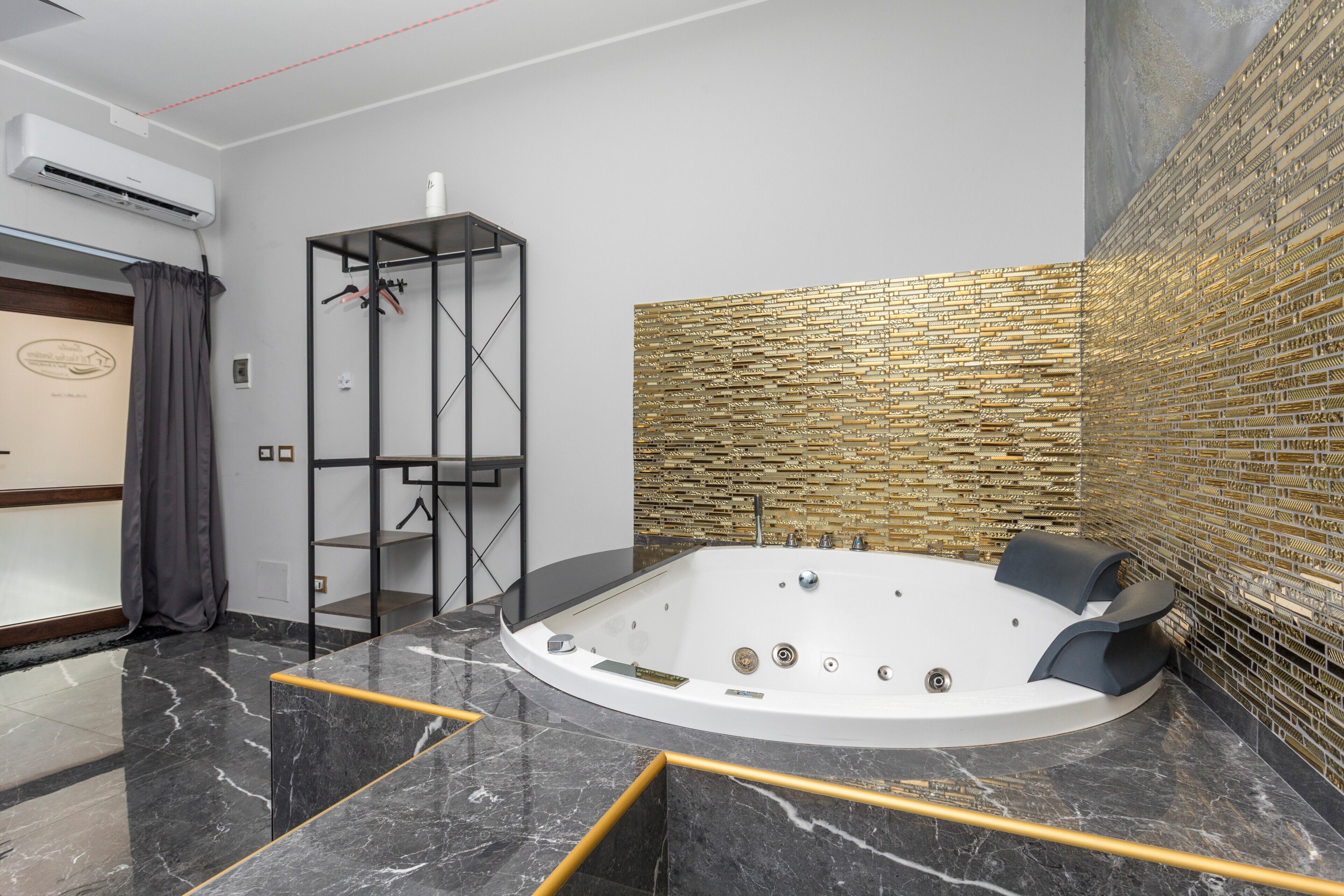 Ein modernes Badezimmer mit Marmorboden, freistehender Badewanne und Wandgestaltung mit Ziegeloptik.