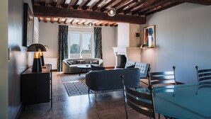 Una sala de estar con sofá, una mesa de vidrio y una chimenea.