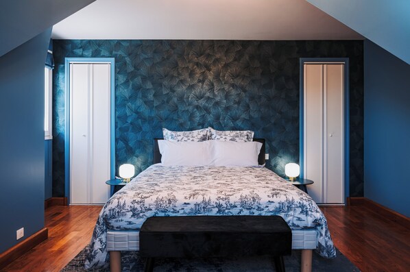 A bedroom with a bed, two bedside tables, and a bench.