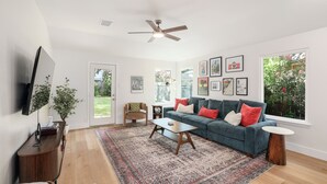 A modern living room with a sofa, coffee table, and a large rug.
