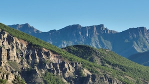 Un paysage montagneux caractérisé par des falaises abruptes et une végétation luxuriante.