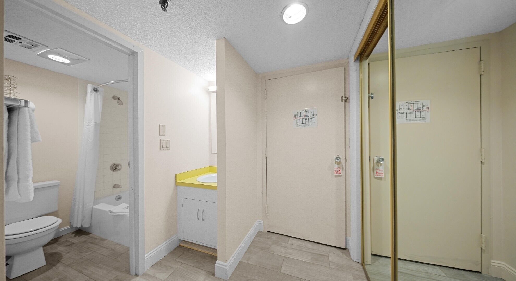 A bathroom with a toilet, shower, and sink.