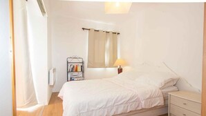 Una camera da letto con un letto, un comodino, una lampada e una libreria.