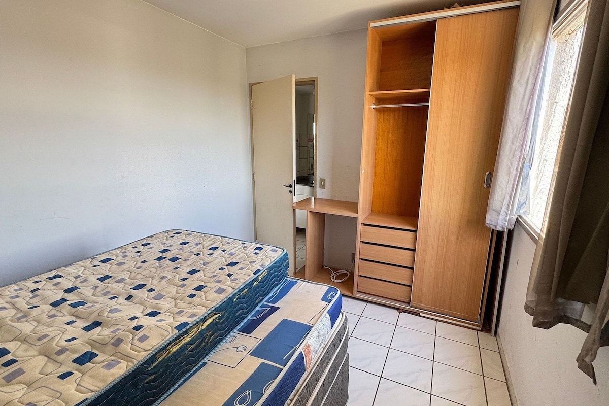 Ein Schlafzimmer mit einem Bett, einem Kleiderschrank und einem kleinen Schreibtisch.