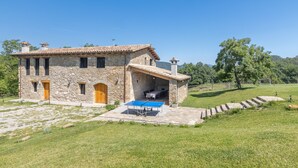 Une maison en pierre avec un patio et une table de ping-pong.